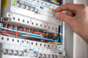 Man,,An,Electrical,Technician,Working,In,A,Switchboard,With,Fuses.